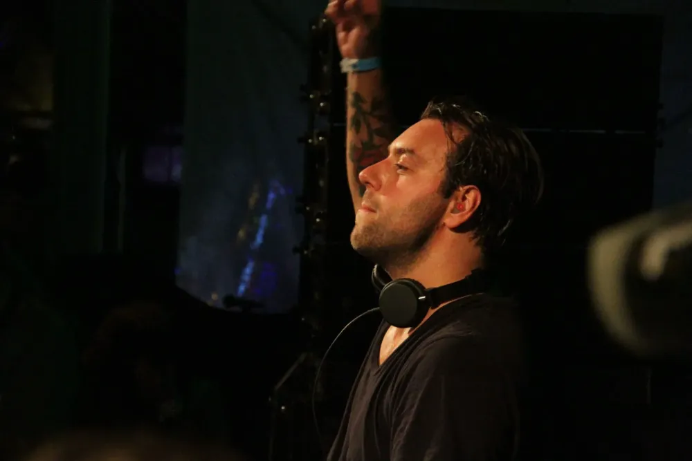 Sebastian Ingrosso en concert, bras levé au-dessus des platines
